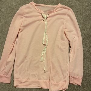 Pink long sleeve shirt with white tie strings in the front